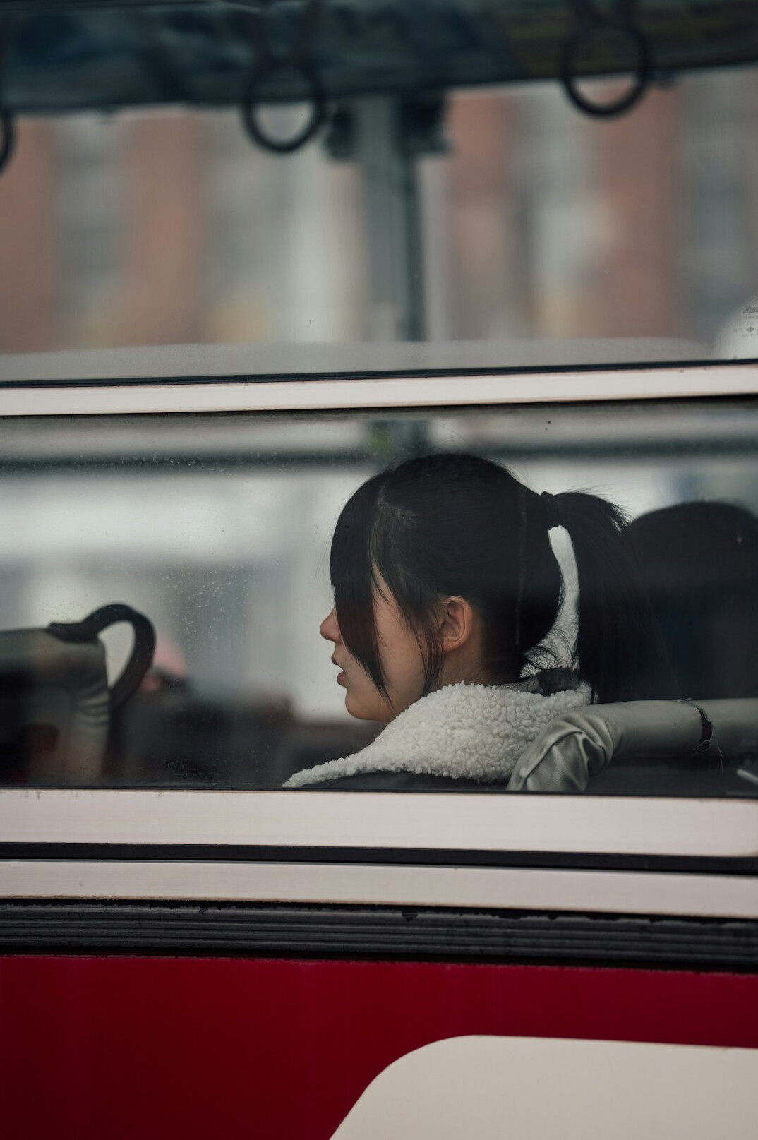 person gazing out of bus window